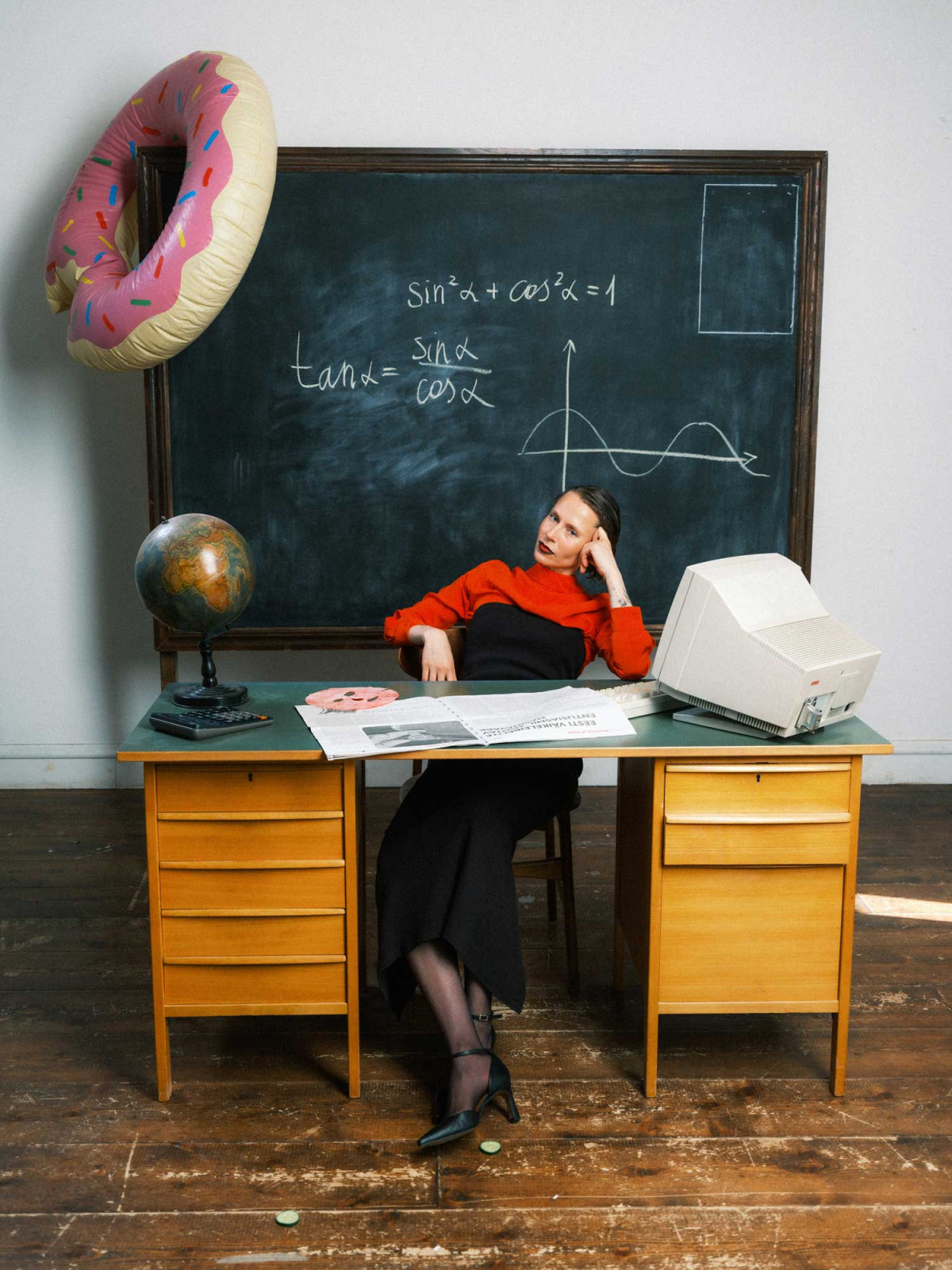 Woman in black-and-red clothing sitting on a chair in classroom environment